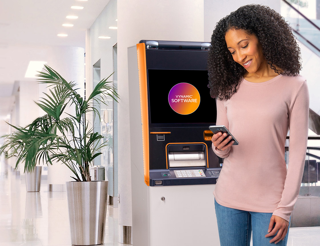 Woman using phone in front of DN Series ATM